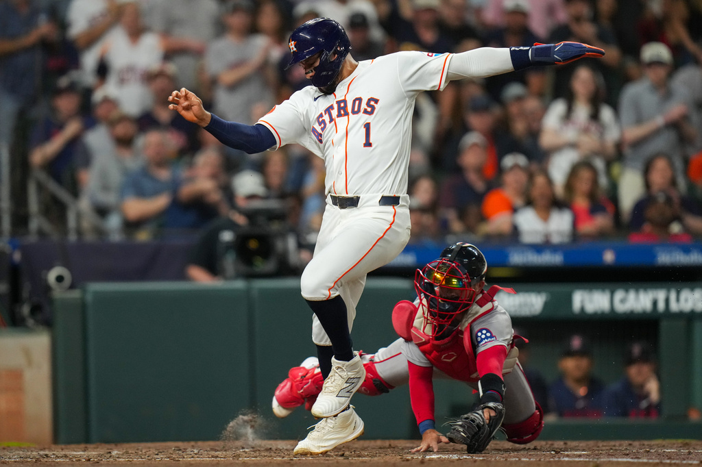 Houston Astros' Carlos Correa beats the tag from Boston Red Sox catcher Connor Wong to score during the third inning of a baseball game in Houston, Tuesday, March 31, 2026. (AP Photo/Jon Shapley)