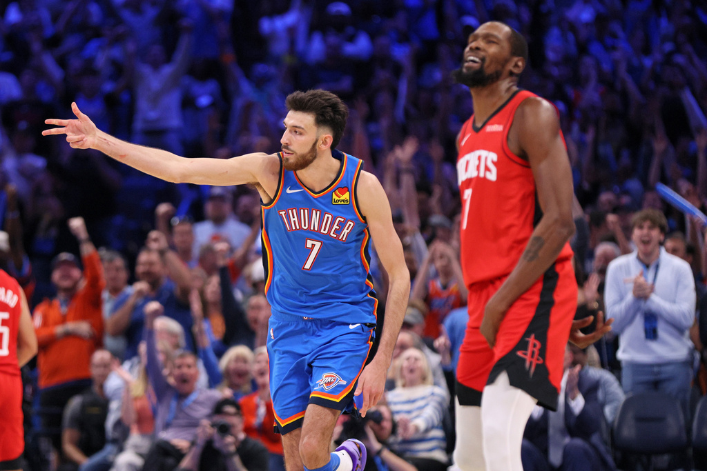 Oklahoma City Thunder center Chet Holmgren, left, celebrates after making a shot near Houston Rockets forward Kevin Durant, right, during the first overtime of an NBA basketball game Tuesday, Oct. 21, 2025, in Oklahoma City. (AP Photo/Nate Billings)