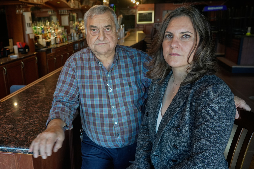 Tania Nemer, right, poses for a portrait with her father, Manuel Nemer, inside his business, Manny's Pub, Thursday, Oct. 9, 2025, in Akron, Ohio. (AP Photo/Sue Ogrocki)
