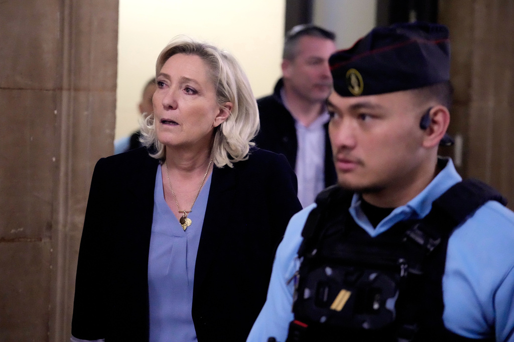 Far-right leader Marine Le Pen, left, walks outside the courtroom during a short break in her appeals trial in Paris, Tuesday, Jan. 20, 2026. (AP Photo/Michel Euler)