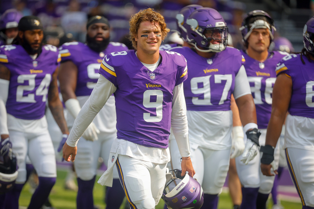 FILE - Minnesota Vikings quarterback J.J. McCarthy (9) warms up with teammates before an NFL preseason football game against the Baltimore Ravens, Aug. 22, 2026, in Minneapolis. (AP Photo/Bruce Kluckhohn, File)