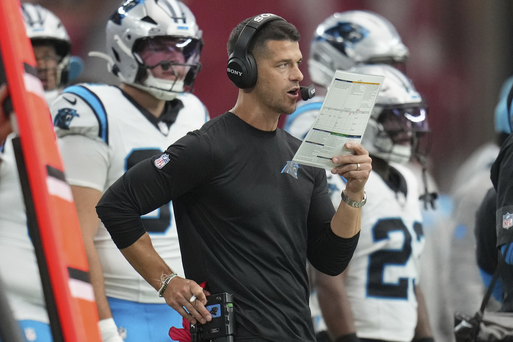 Carolina Panthers head coach Dave Canales make a call during the first half of an NFL football game against the Arizona Cardinals, Sunday, Sept. 14, 2025, in Glendale, Ariz. (AP Photo/Rick Scuteri)