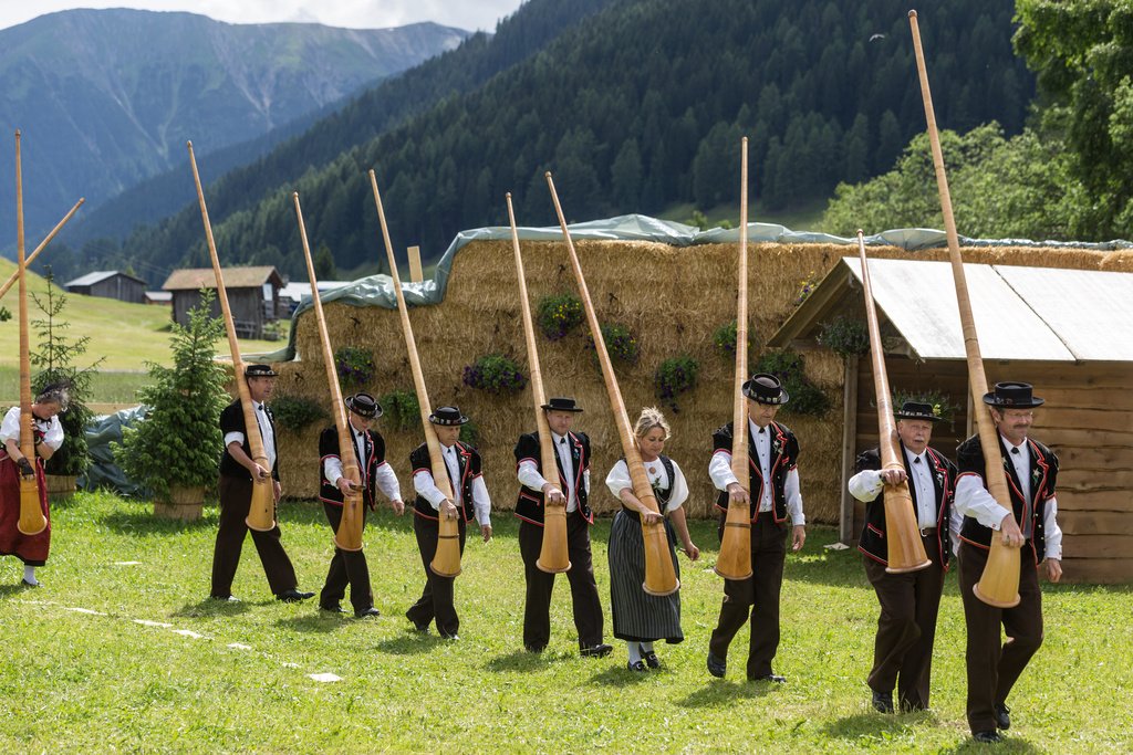 A group of Swiss Alphorn blowers arrive at the Yodel Festival in Davos, Switzerland, July 5, 2014. (Arno Balzarini/Keystone via AP)