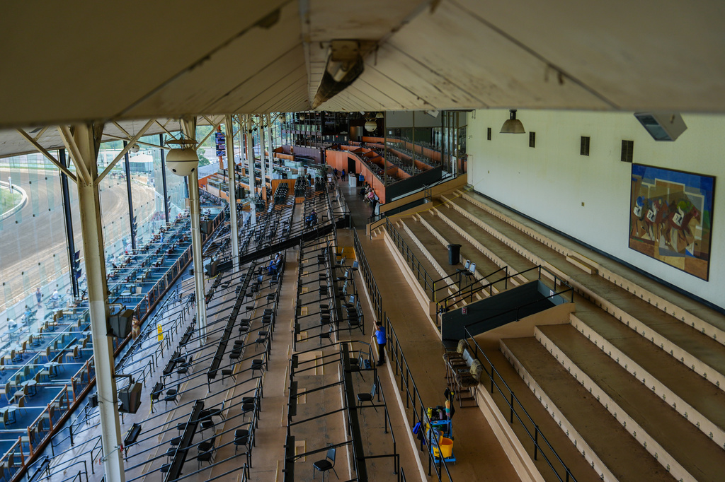 The Laurel Park grandstand sits almost empty as a janitor mops the floor during live racing, Friday, May 8, 2026, in Laurel, Md. (AP Photo/Julia Demaree Nikhinson)