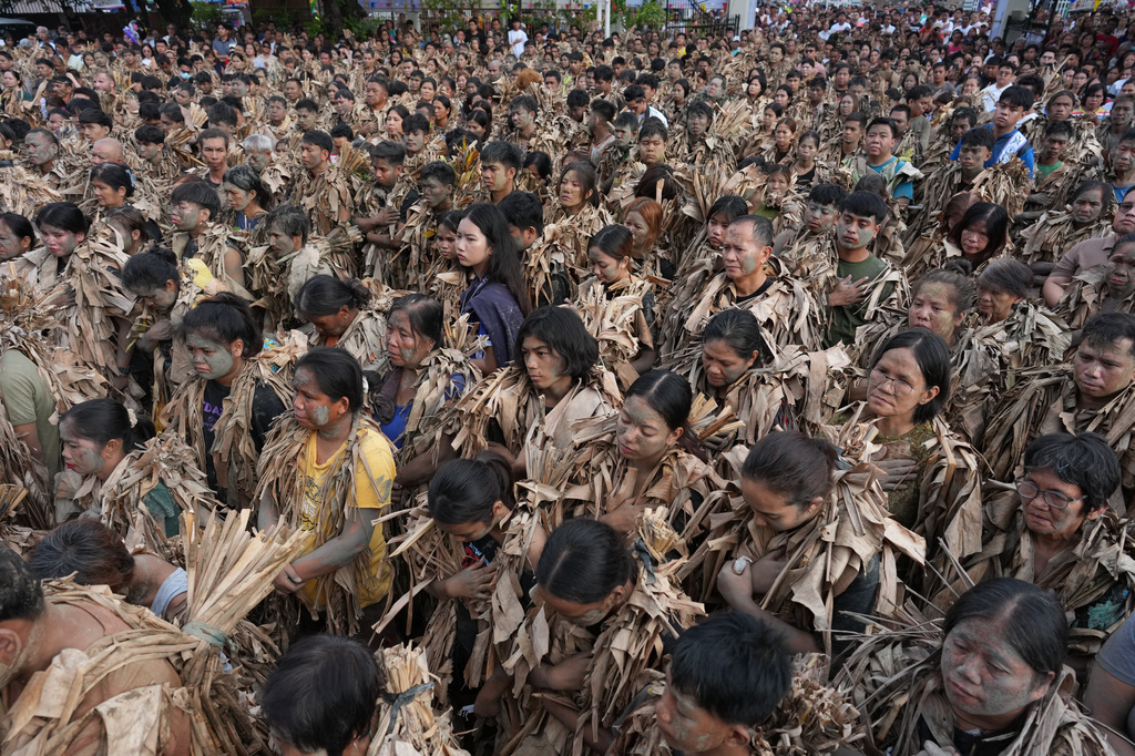 Catholic devotee covered in mud and dried banana leaves participate at the mud people festival on the feast day of Saint John the Baptist at Bibiclat, Nueva Ecija province, northern Philippines on Wednesday, June 24, 2026. (AP Photo/Aaron Favila)