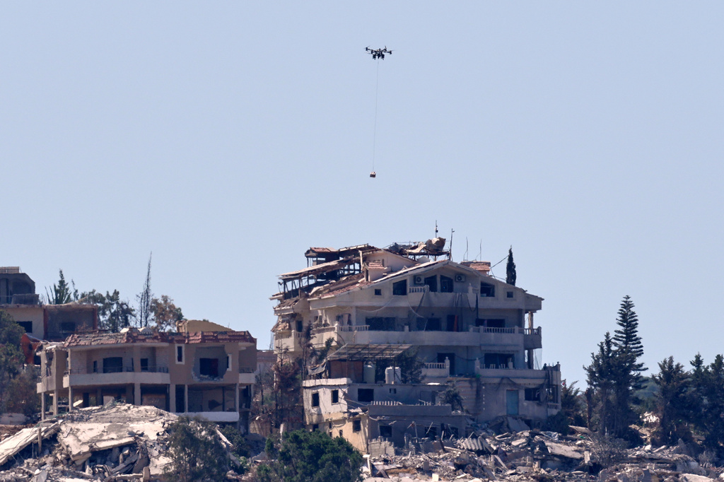An Israeli drone carries a box of explosives to be dropped on houses in Mansouri village for detonation, as seen from Hanniyeh village, southern Lebanon, Friday, Sept. 11, 2026. (AP Photo/Hussein Malla)