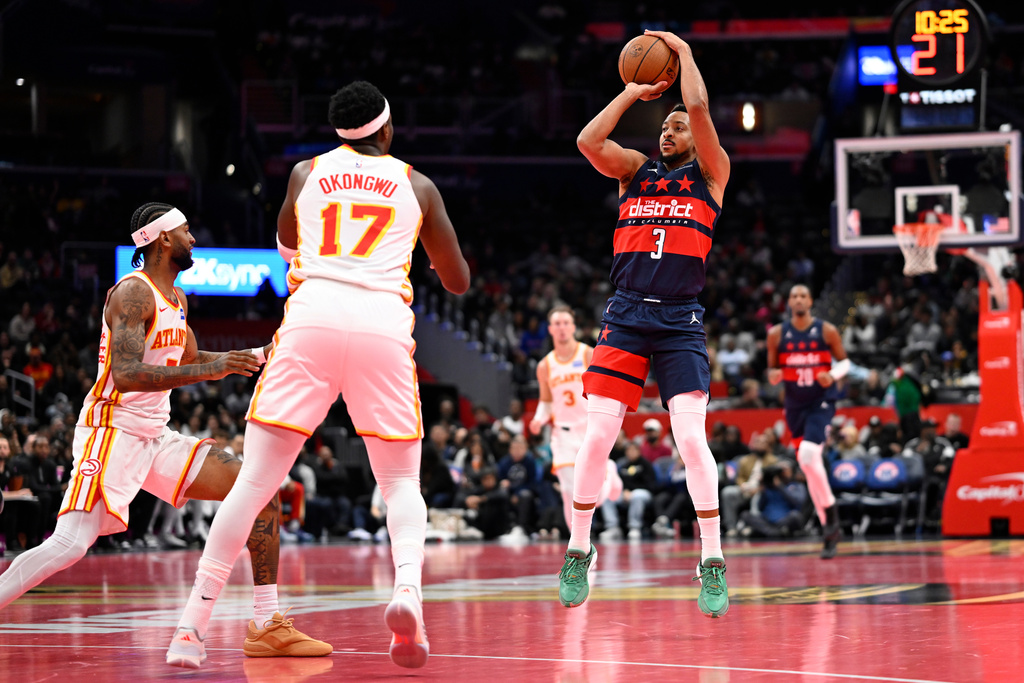 Washington Wizards guard CJ McCollum (3) launches a three point shot in front of Atlanta Hawks forward Onyeka Okongwu (17) during the first half of a Emirates NBA Cup basketball game Tuesday, Nov. 25, 2025, in Washington. (AP Photo/John McDonnell)