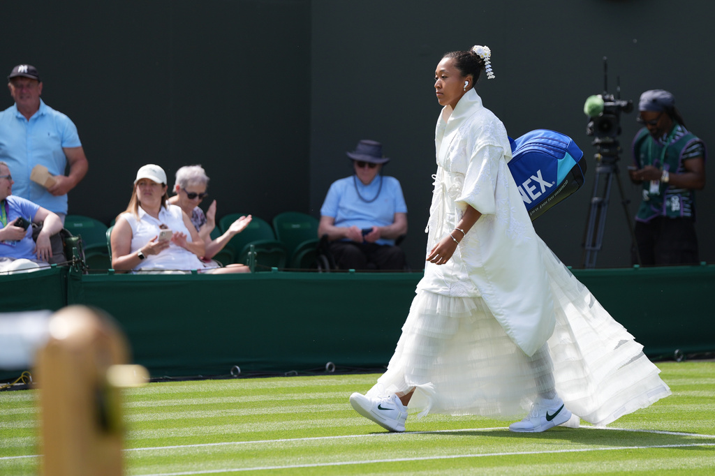Naomi Osaka of Japan walks into the court to play against Elsa Jacquemot of France in their first round women's singles match at the Wimbledon Tennis Championships in London, Monday, June 29, 2026. (AP Photo/Maja Smiejkowska)