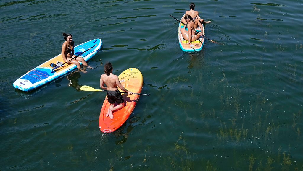 Paddleboarders pause while paddling on Lake of the Isles during an extreme heat warning, Monday, July 13, 2026, in Minneapolis. (AP Photo/Ellen Schmidt)
