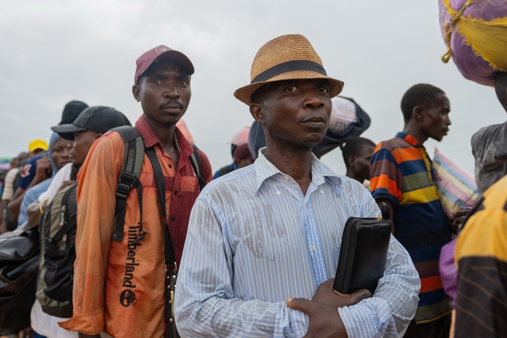 Burundian citizens who work in Uvira, Democratic Republic of the Congo, and could not cross back into their home country due to fighting, cross the border into Burundi, Sunday, Dec. 14, 2025. (AP Photo/Moses Sawasawa)