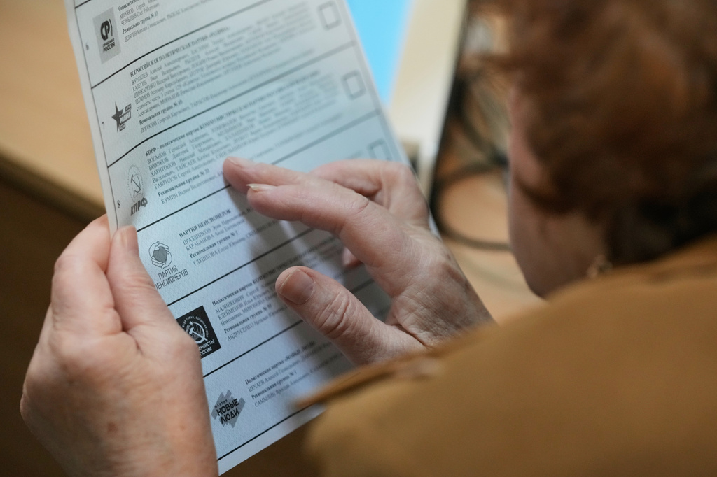 A voter looks through a ballot during the parliamentary election in Moscow, Sunday, Sept. 20, 2026. (AP Photo/Pavel Bednyakov)