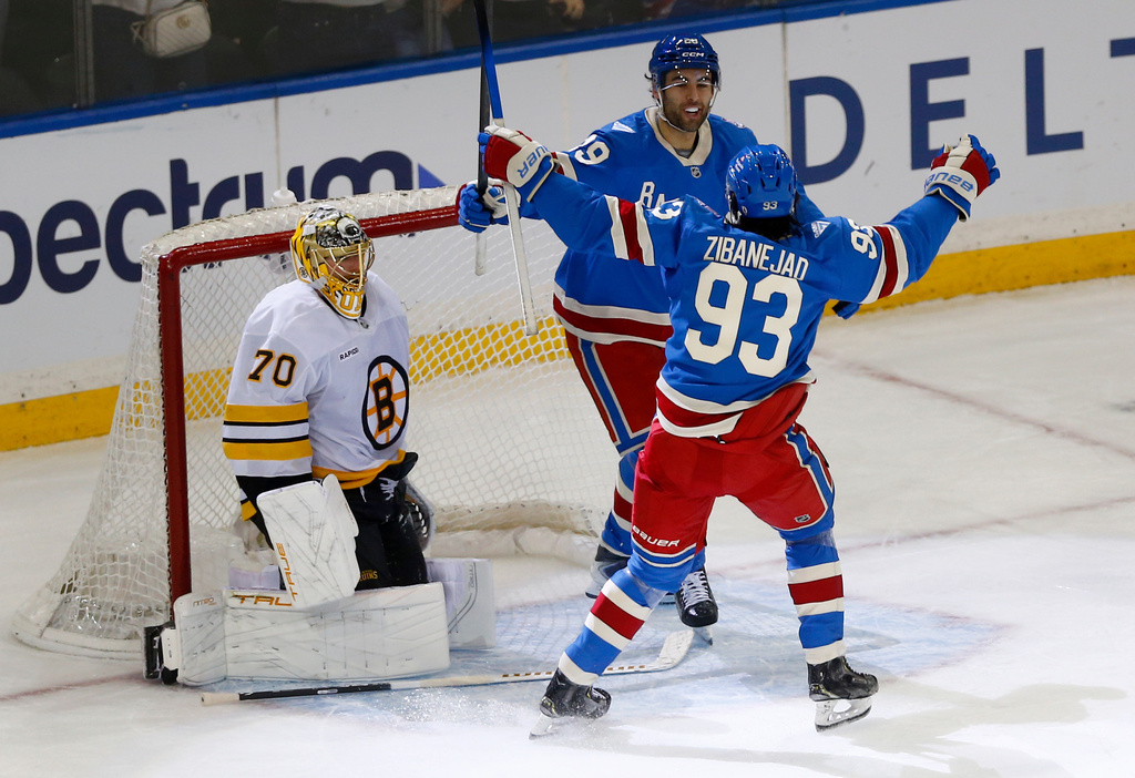 New York Rangers defenseman Matthew Robertson, top right, is congratulated by center Mika Zibanejad (93) as Boston Bruins goalie Joonas Korpisalo (70) looks on after Robertson scored the winning goal in overtime of an NHL hockey game Monday, Jan. 26, 2026, in New York. (AP Photo/John Munson)