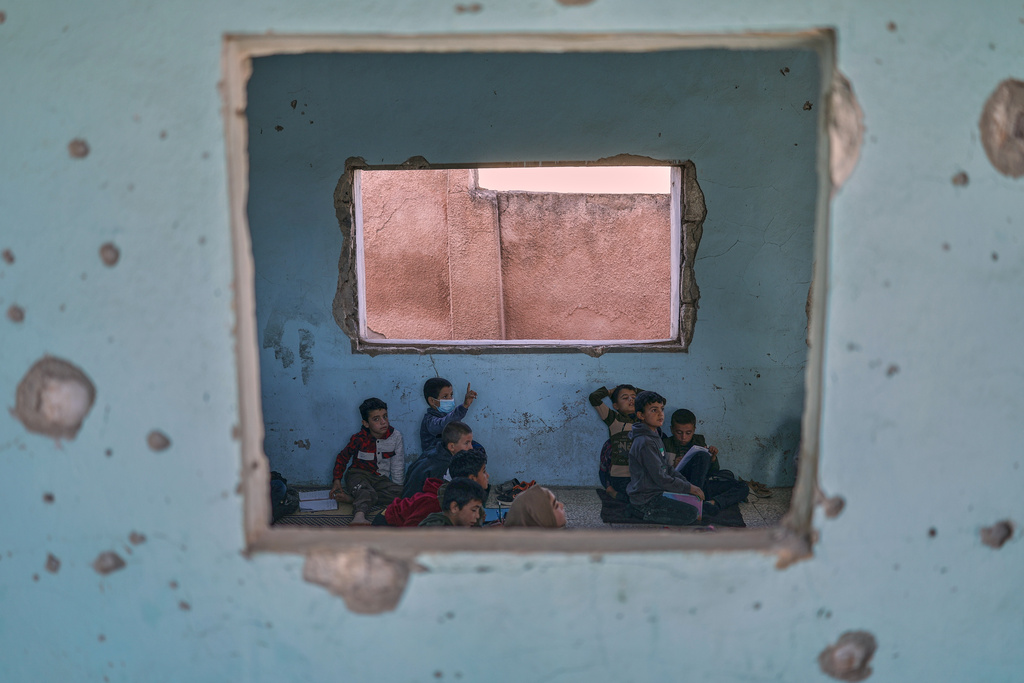 Students attend class inside the Maar Shmarin Primary School, its walls scarred by bullet holes from the fighting between forces loyal to former President Bashar Assad and rebel groups, in the village of Maar Shmarin, in the Idlib countryside, Syria, Sunday, Oct. 19, 2025. (AP Photo/Ghaith Alsayed)