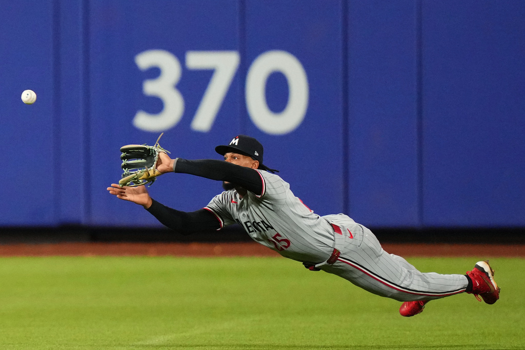 Minnesota Twins' Byron Buxton dives to catch a ball hit by New York Mets' Marcus Semien for an out to end the eighth inning of a baseball game Wednesday, April 22, 2026, in New York. (AP Photo/Frank Franklin II)