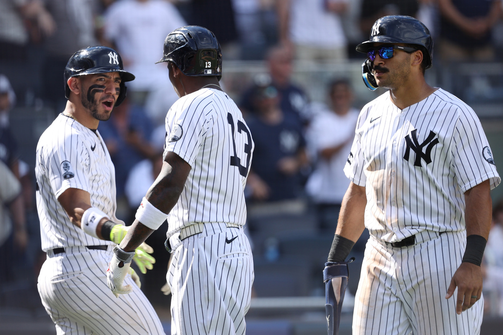 New York Yankees players, from left, José Caballero, Jazz Chisholm Jr. and Trent Grisham react after Chisholm Jr. hit a three run home run in the eighth inning of a baseball game against the Boston Red Sox, Sunday, June 7, 2026, in New York. (AP Photo/Pamela Smith)