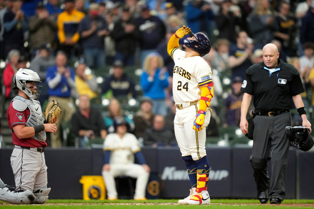 Milwaukee Brewers' William Contreras (24) reacts to hitting a two-run home run as Arizona Diamondbacks catcher James McCann, left, look on during the third inning of a baseball game, Thursday, April 30, 2026, in Milwaukee. (AP Photo/Kayla Wolf)