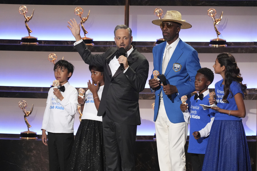 Host Nate Bargatze, left, JB Smoove and children from the Girls and Boys Club appear on stage during the 77th Primetime Emmy Awards on Sunday, Sept. 14, 2025, at the Peacock Theater in Los Angeles. (AP Photo/Chris Pizzello)