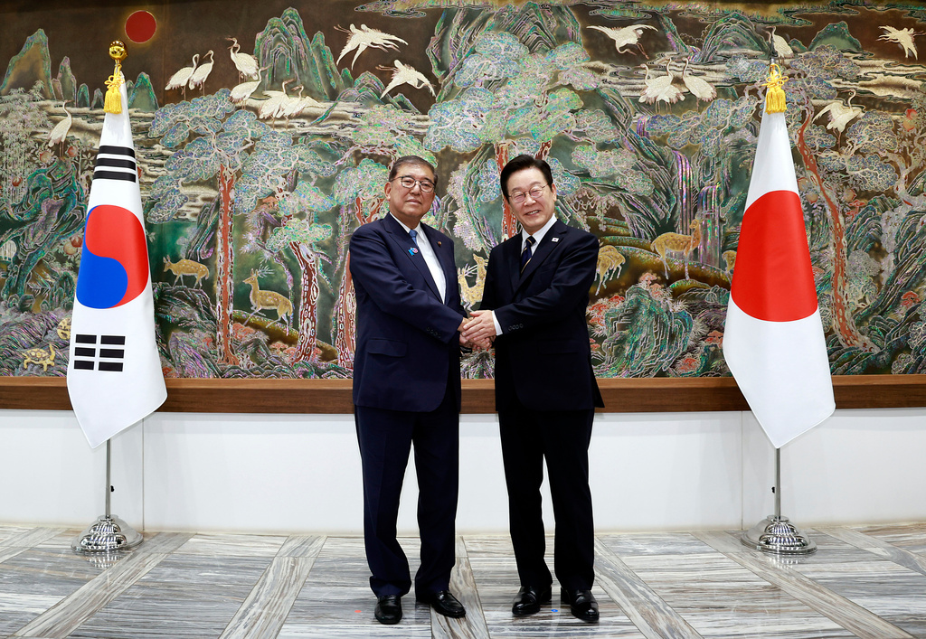 South Korean President Lee Jae Myung, right, shakes hands with Japanese Prime Minister Shigeru Ishiba during a meeting in Busan, South Korea, Tuesday, Sept. 30, 2025. (Yonhap via AP)