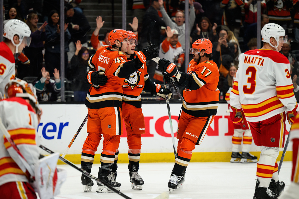 Anaheim Ducks right wing Beckett Sennecke (45) is greeted by teammates after scoring during the first period of an NHL hockey game against the Calgary Flames, Saturday, April 4, 2026, in Anaheim, Calif. (AP Photo/William Liang)