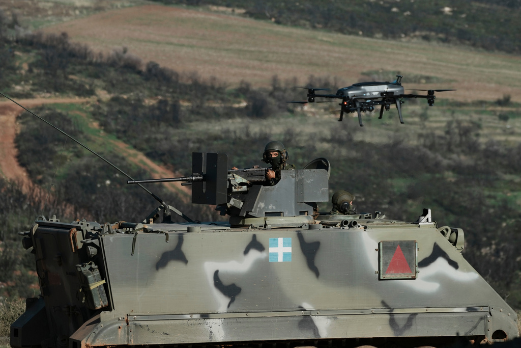 A drone flies above a Greek army armored vehicle in a live-fire exercise near the northeastern city of Alexandroupolis, Greece, testing domestically-developed drones and counter-drone systems as part of NATO's modernization efforts on Friday, Nov. 14, 2025. (AP Photo/Thanassis Stavrakis)