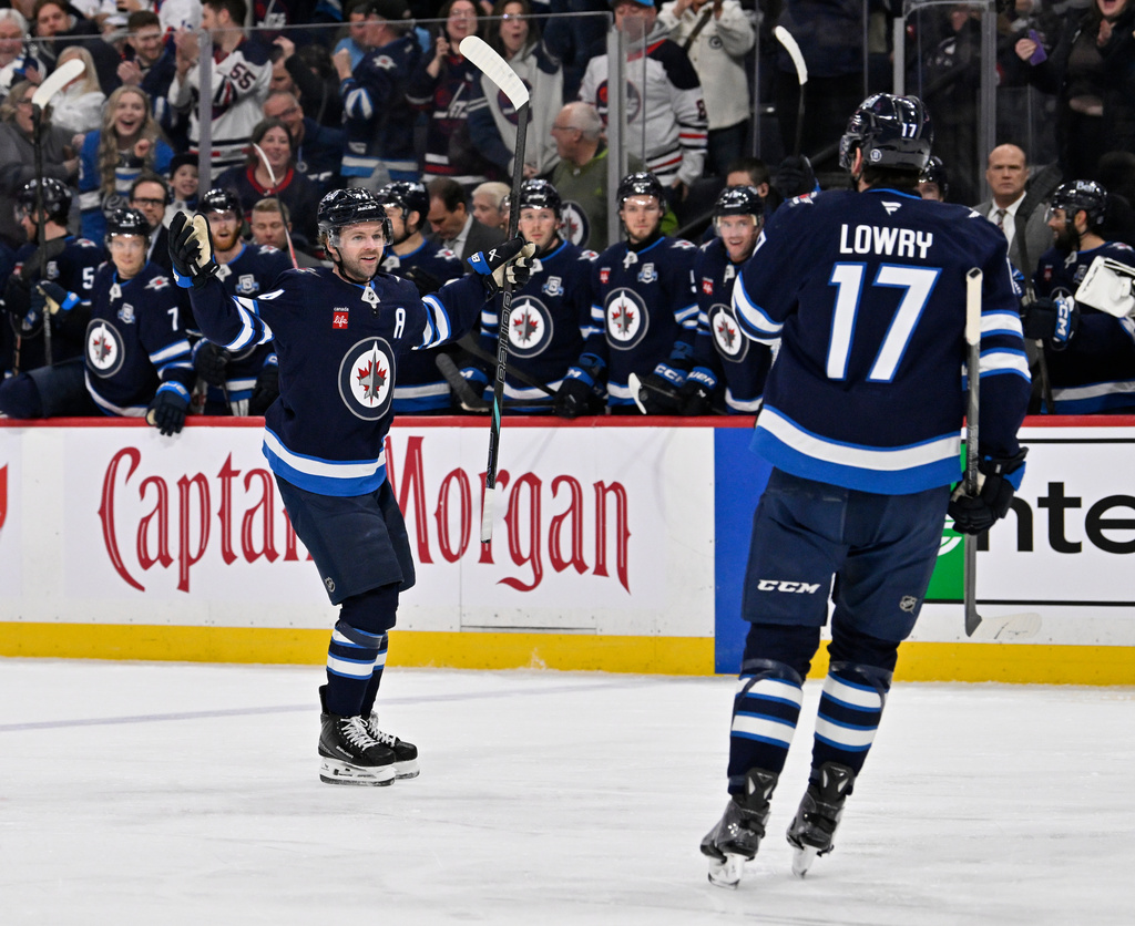 Winnipeg Jets' Josh Morrissey (44) celebrates his goal on the New York Islanders with Adam Lowry (17) during the second period of their NHL hockey game, in Winnipeg, Manitoba, Tuesday, Jan. 13, 2026. (Fred Greenslade/The Canadian Press via AP)