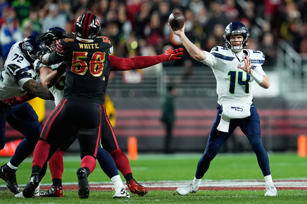 Seattle Seahawks quarterback Sam Darnold (14) passes against San Francisco 49ers defensive end Keion White (56) during the first half of an NFL football game in Santa Clara, Calif., Saturday, Jan. 3, 2026. (AP Photo/Godofredo A. Vásquez)