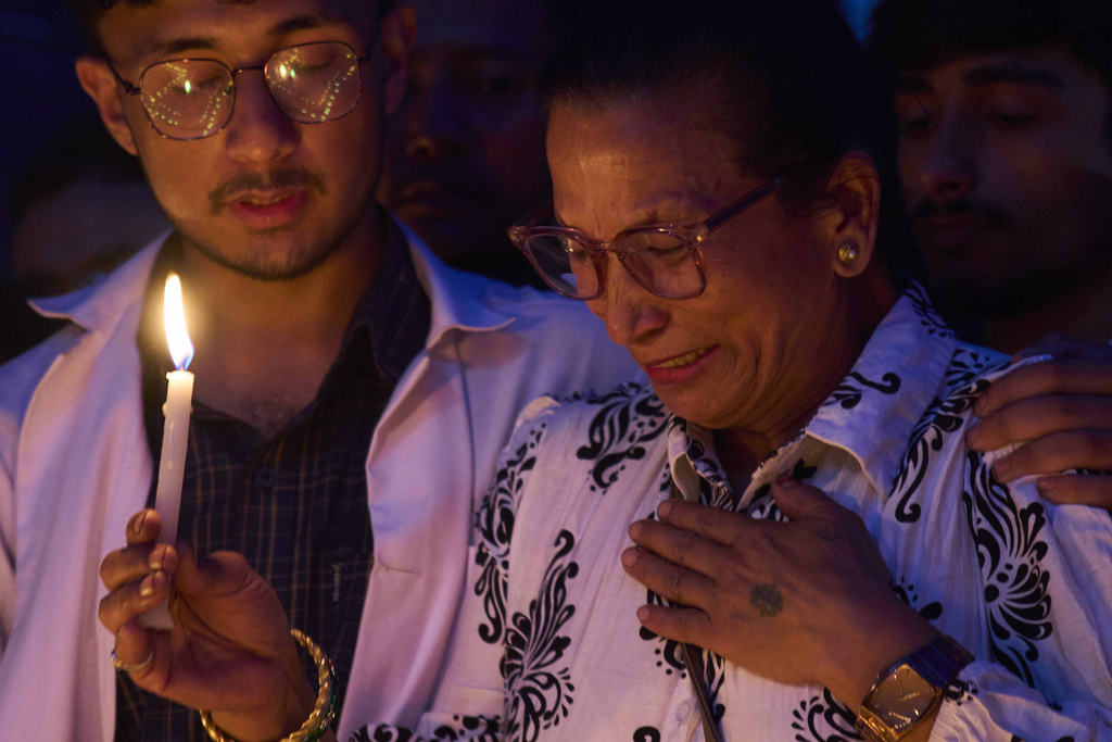 Family members of people killed during the Sept. 8 protest participate in a candlelight vigil outside the morgue of Teaching Hospital in Kathmandu, Nepal, Thursday, Sept. 11, 2025. (AP Photo/Niranjan Shrestha)