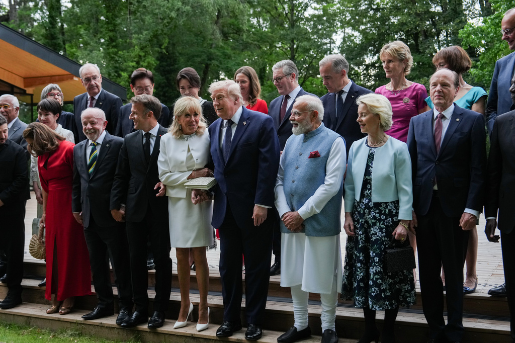 President Donald Trump helps France's first lady Brigitte Macron up a step as she arrives for a group photo with leaders and their spouses at the G7 summit, Tuesday, June 16, 2026, in Evian-les-Bains, France. (AP Photo/Julia Demaree Nikhinson)