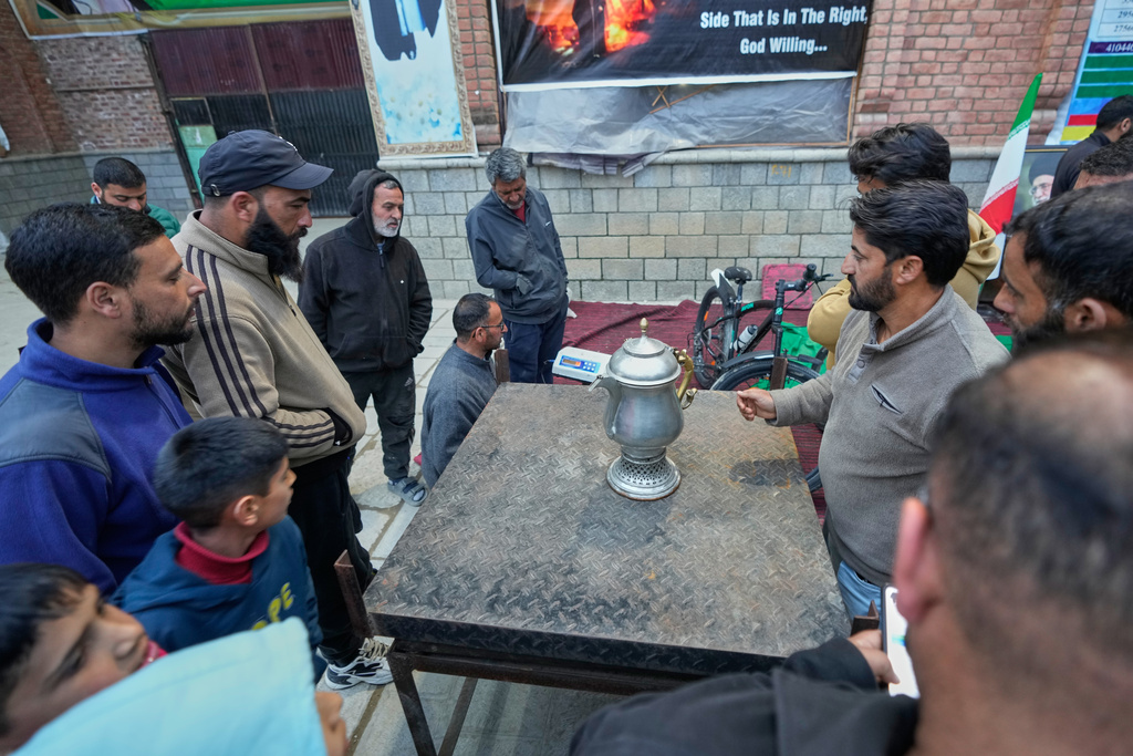 A volunteer auctions a donated copper vessel to raise cash for a relief drive for Iran in Budgam, Indian-controlled Kashmir, Monday, March 23, 2026. (AP Photo/Mukhtar Khan)