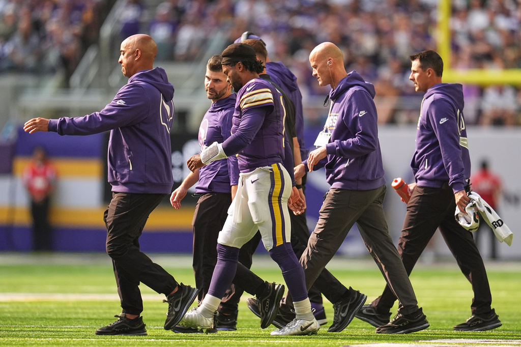 Minnesota Vikings quarterback Kyler Murray, center, walks off the field with staff after suffering an unknown injury during the first half of an NFL football game against the Green Bay Packers Sunday, Sept. 13, 2026, in Minneapolis, Minn. (AP Photo/Abbie Parr)