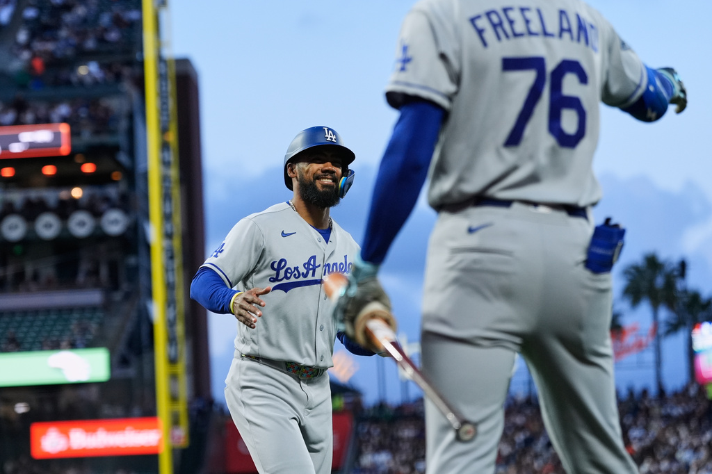 Los Angeles Dodgers' Teoscar Hernández, left, celebrates with Alex Freeland after scoring against the San Francisco Giants during the fourth inning of a baseball game Tuesday, April 21, 2026, in San Francisco. (AP Photo/Godofredo A. Vásquez)