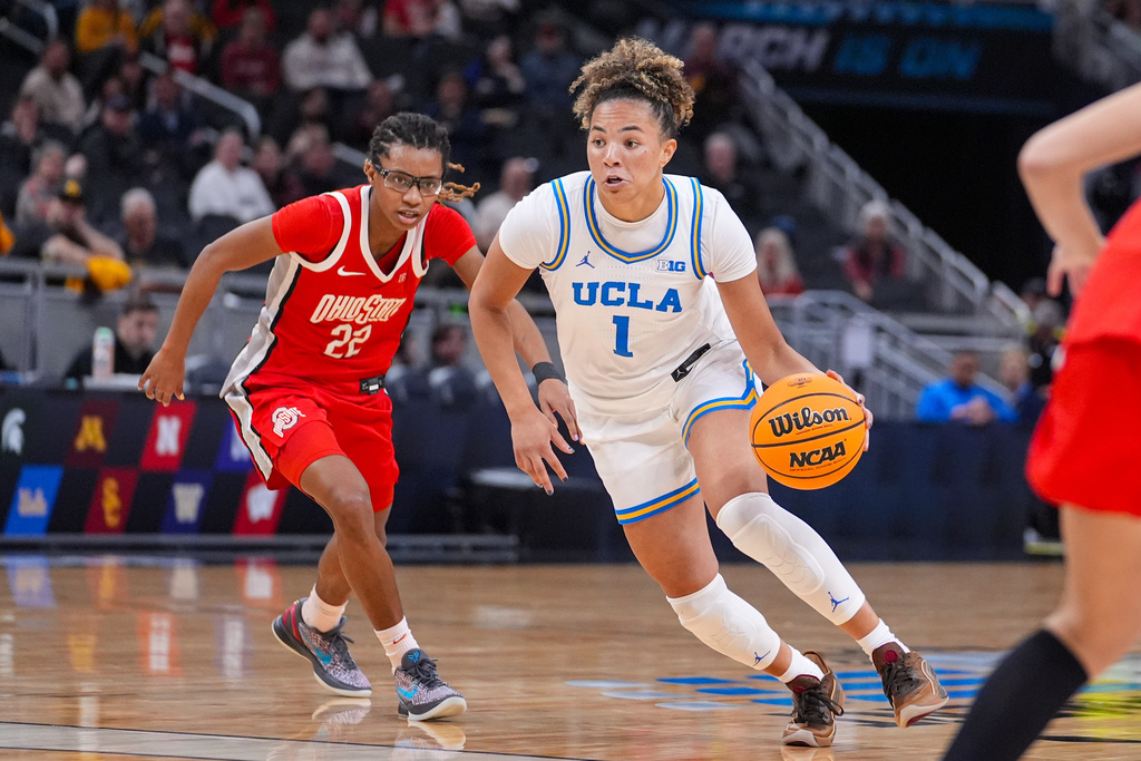 UCLA guard Kiki Rice (1) drives on Ohio State guard Jaloni Cambridge (22) in the second half of an NCAA college basketball game in the semifinals of the Big Ten Conference tournament, Saturday, March 7, 2026 in Indianapolis. (AP Photo/Michael Conroy)