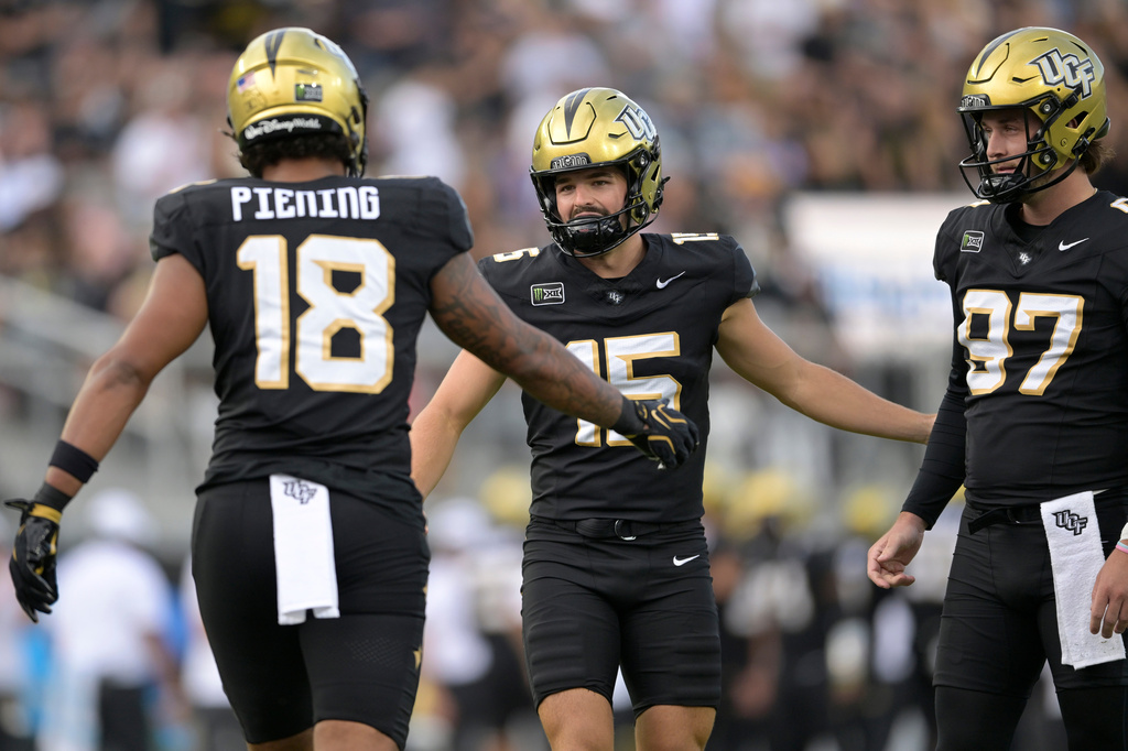 Central Florida kicker Will Stone (15) is congratulated by Caden Piening (18) and Mason Denaburg (97) after kicking a 19-yard field goal during the first half of an NCAA college football game against BYU, Saturday, Oct. 24, 2026, in Orlando, Fla. (AP Photo/Phelan M. Ebenhack)