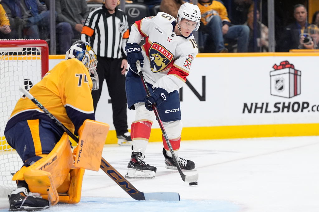 Florida Panthers center Anton Lundell (15) shoots the puck against the Nashville Predators goaltender Juuse Saros (74) during the first period of an NHL hockey game Monday, Nov. 24, 2025, in Nashville, Tenn. (AP Photo/George Walker IV)