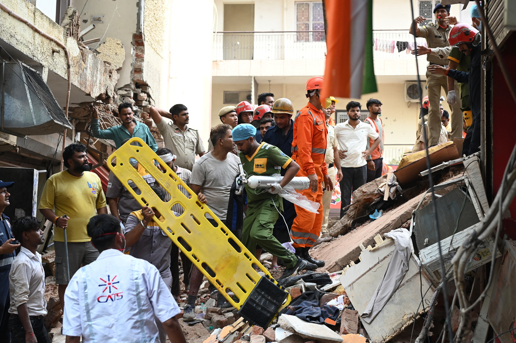 Rescue workers look for the trapped survivors under the debris of a building that collapsed in New Delhi, India, Sunday, Sept. 6, 2026. (AP Photo/ Vipin)