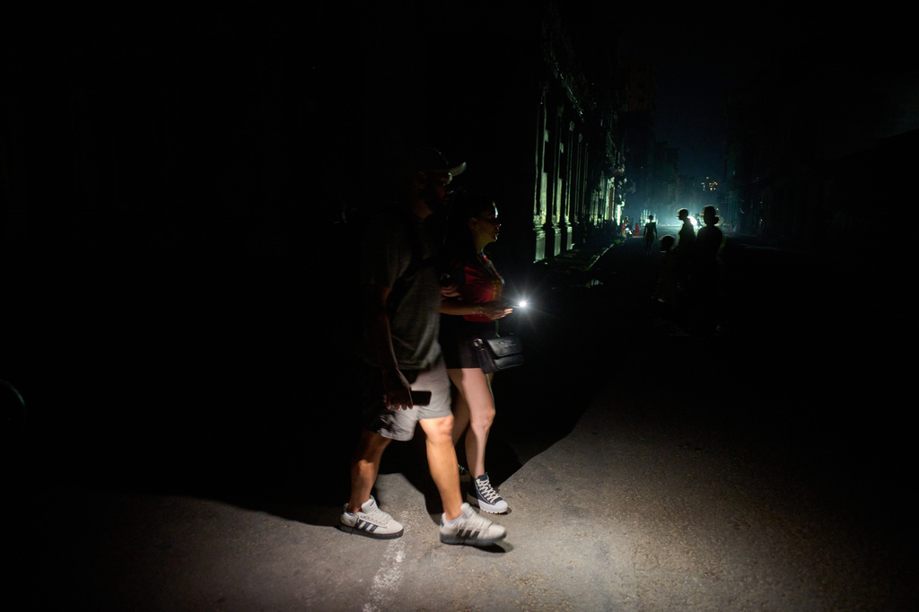 People walk along a street using flashlights during a blackout in Havana, Cuba, Monday, July 6, 2026. (AP Photo/Ramon Espinosa)