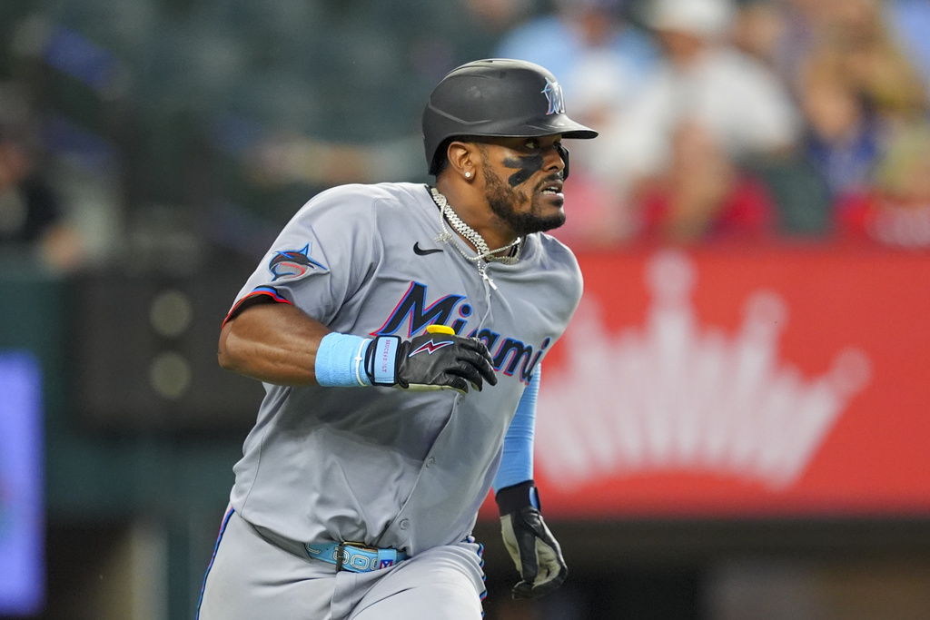 Miami Marlins' Brian Navarreto looks at his ball as he hits a sacrifice fly ball to score teammate Graham Pauley during the seventh inning of a baseball game against the Texas Rangers Sunday, Sept. 21, 2025, in Arlington, Texas. (AP Photo/Ronaldo Bolaños)