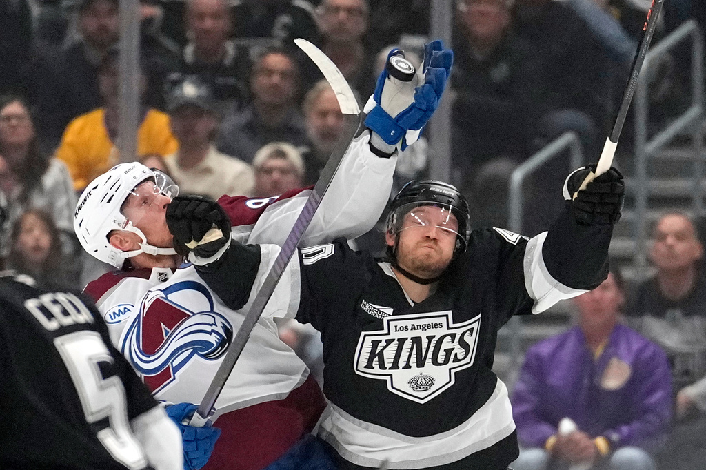 Colorado Avalanche left wing Gabriel Landeskog, left, and Los Angeles Kings right wing Joel Armia reach for the puck during the first period of Game 3 in the first round of the NHL hockey Stanley Cup playoffs Thursday, April 23, 2026, in Los Angeles. (AP Photo/Mark J. Terrill)