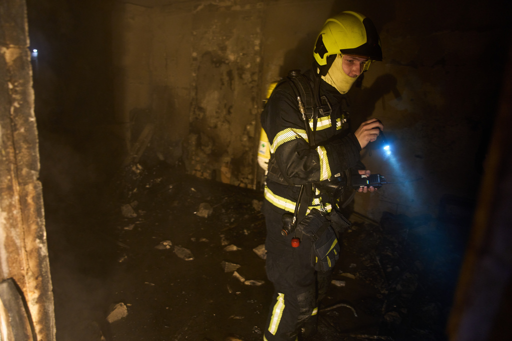 A rescuer searches for victims after a drone hit a residential building during Russia's night missile and drone attack in Kyiv, Ukraine, Saturday, Nov. 29, 2025. (AP Photo/Efrem Lukatsky)