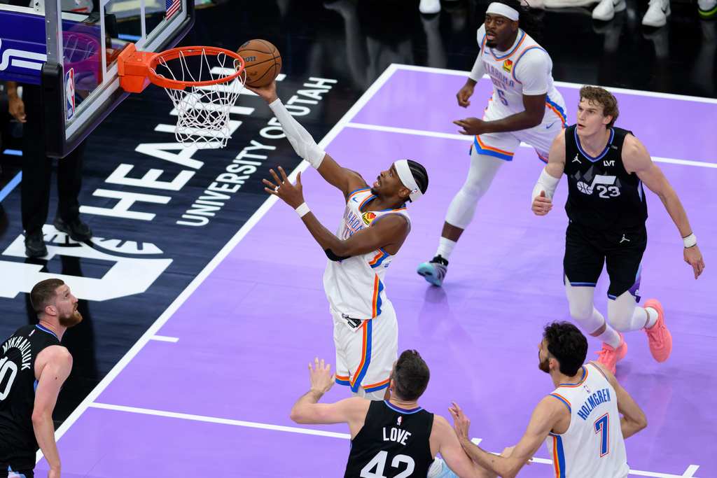 Oklahoma City Thunder guard Shai Gilgeous-Alexander, center, lays the ball into the basket during the second half of an NBA Cup basketball game against the Utah Jazz, Friday, Nov. 21, 2025, in Salt Lake City. (AP Photo/Tyler Tate)