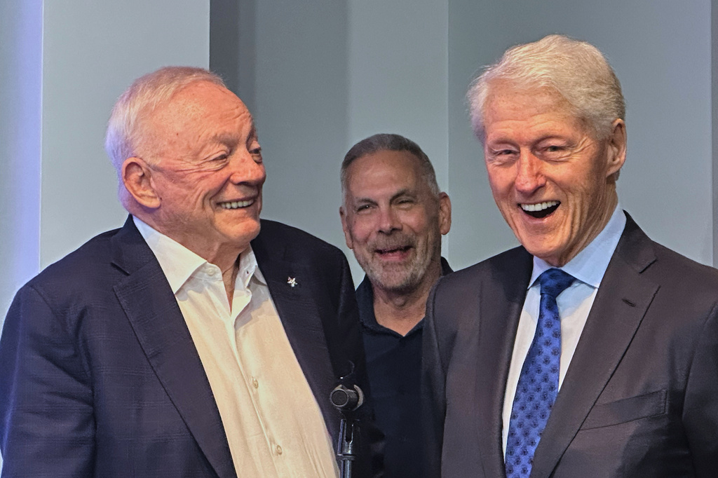 Former U.S. President Bill Clinton, right, laughs alongside Dallas Cowboys owner Jerry Jones, left, and Cowboys senior vice president of communications Tad Carper, center, during the NFL football team's pre-draft news conference Wednesday, April 22, 2026 in Frisco, Texas. (AP Photo/Schuyler Dixon)