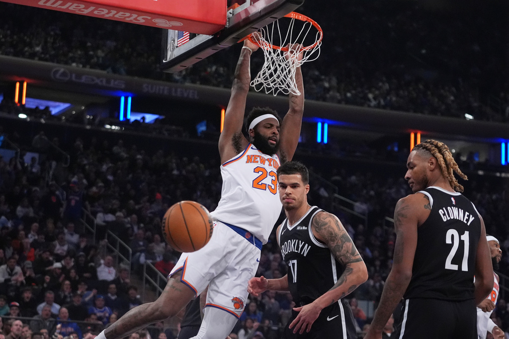 New York Knicks' Mitchell Robinson (23) dunks the ball in front of Brooklyn Nets' Michael Porter Jr. (17) and Noah Clowney (21) during the first half of an NBA basketball game Wednesday, Jan. 21, 2026, in New York. (AP Photo/Frank Franklin II)