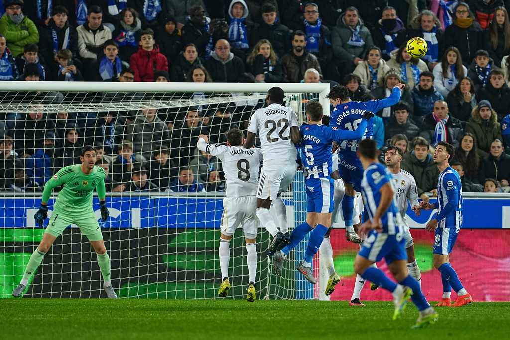 Real Madrid's goalkeeper Thibaut Courtois, left, watches as players challenge for the ball during the Spanish La Liga soccer match between Alaves and Real Madrid in Vitoria-Gasteiz, Spain, Sunday, Dec. 14, 2025. (AP Photo/Miguel Oses)
