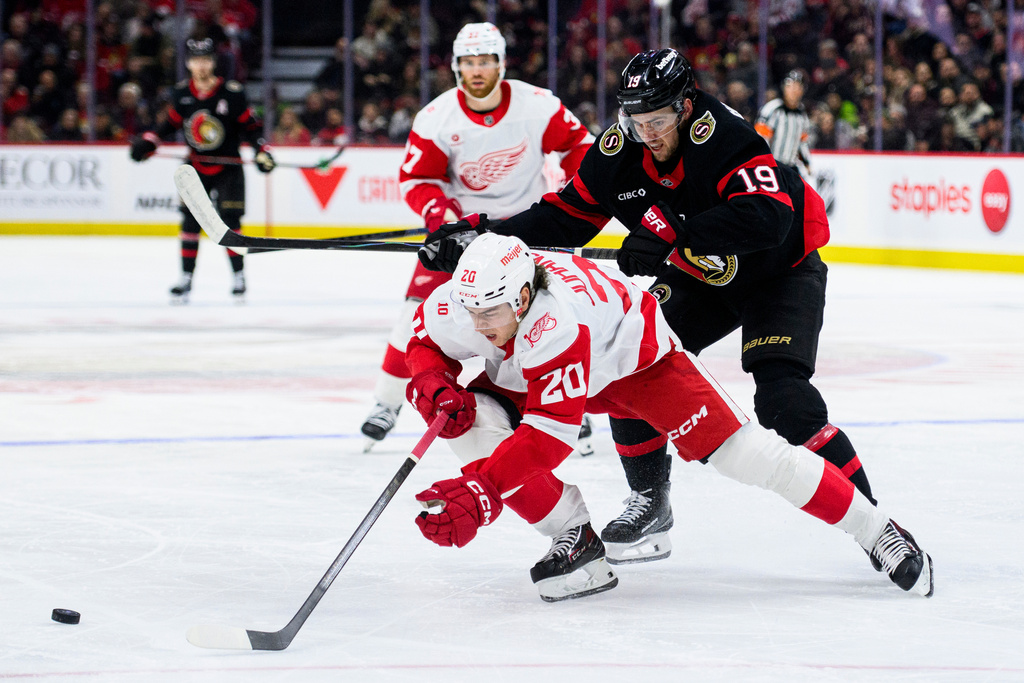 Ottawa Senators' Drake Batherson (19) cross-checks Detroit Red Wings' Albert Johansson (20) as they vie for the puck during second-period NHL hockey game action in Ottawa, Ontario, Monday, Jan. 5, 2026. (Spencer Colby/The Canadian Press via AP)