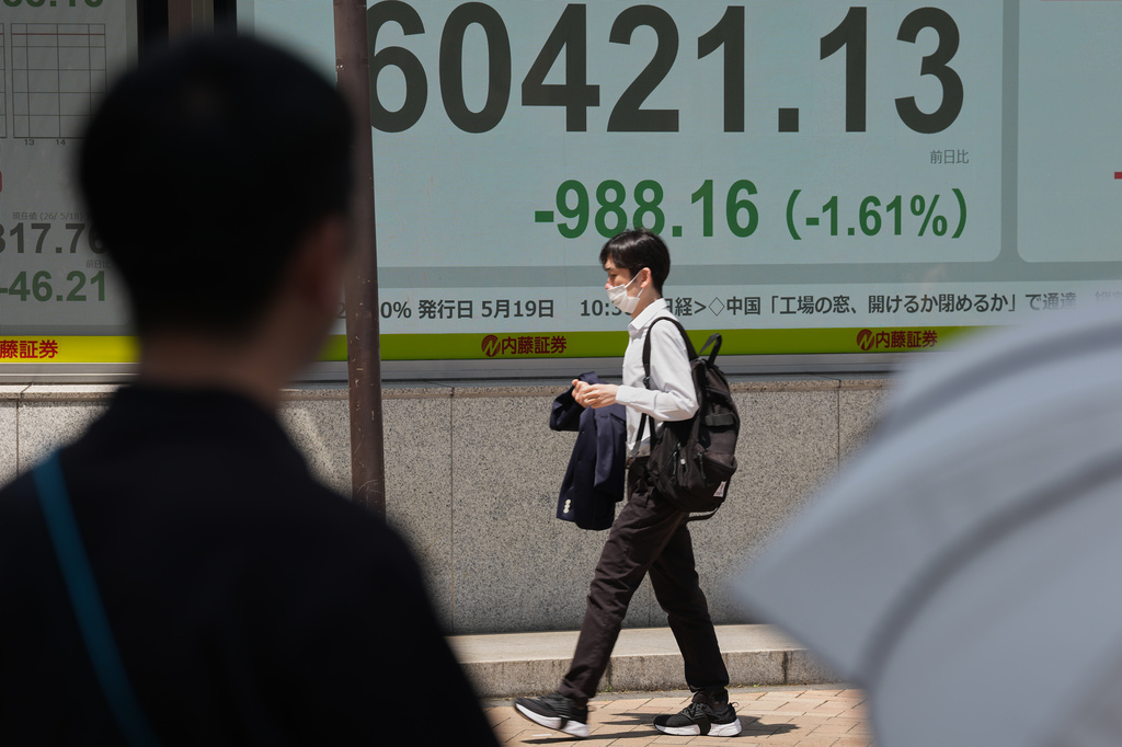 A person walks in front of an electronic stock board showing Japan's Nikkei index at a securities firm Monday, May 18, 2026, in Tokyo. (AP Photo/Eugene Hoshiko)