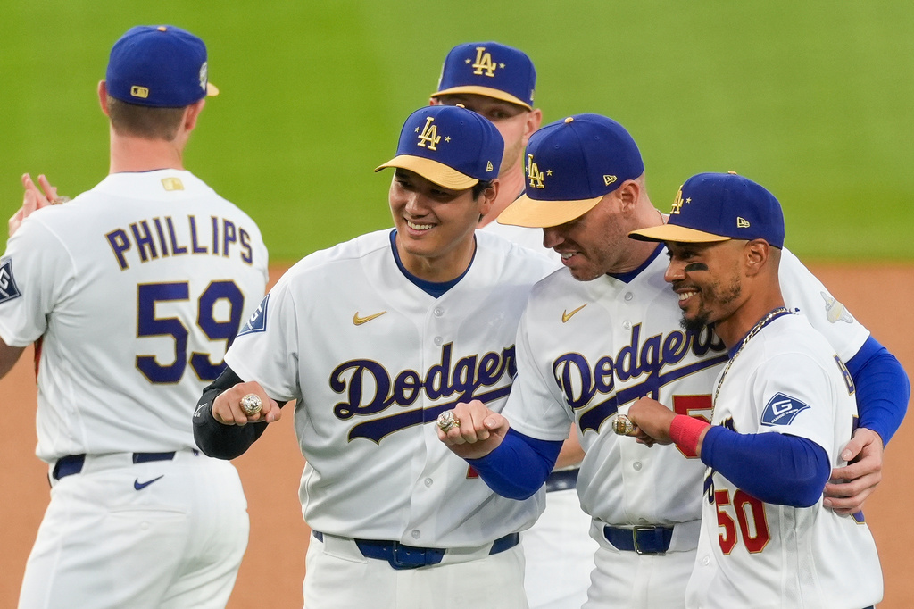 Los Angeles Dodgers Shohei Ohtani, Freddie Freeman and Mookie Betts pose with their rings during a World Series Champion ring ceremony prior to a baseball game against the Arizona Diamondbacks in Los Angeles, Friday, March 27, 2026. (AP Photo/Caroline Brehman)
