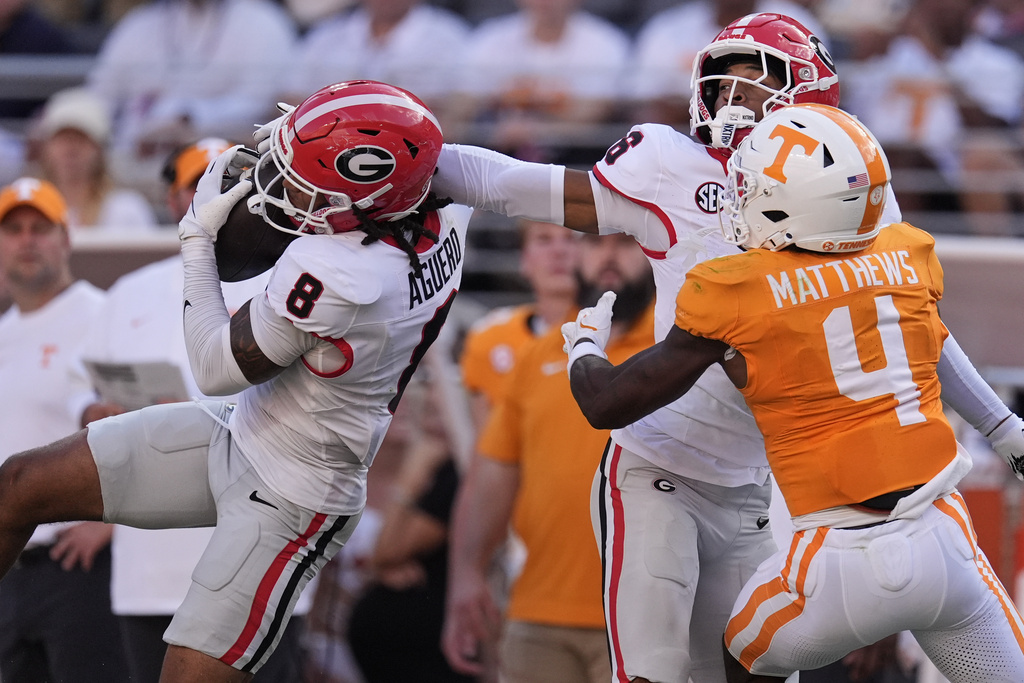 Georgia defensive back Joenel Aguero (8) catches an interception in front of defensive back Daylen Everette (6) and Tennessee wide receiver Mike Matthews (4) during the first half of an NCAA college football game Saturday, Sept. 13, 2025, in Knoxville, Tenn. (AP Photo/George Walker IV)