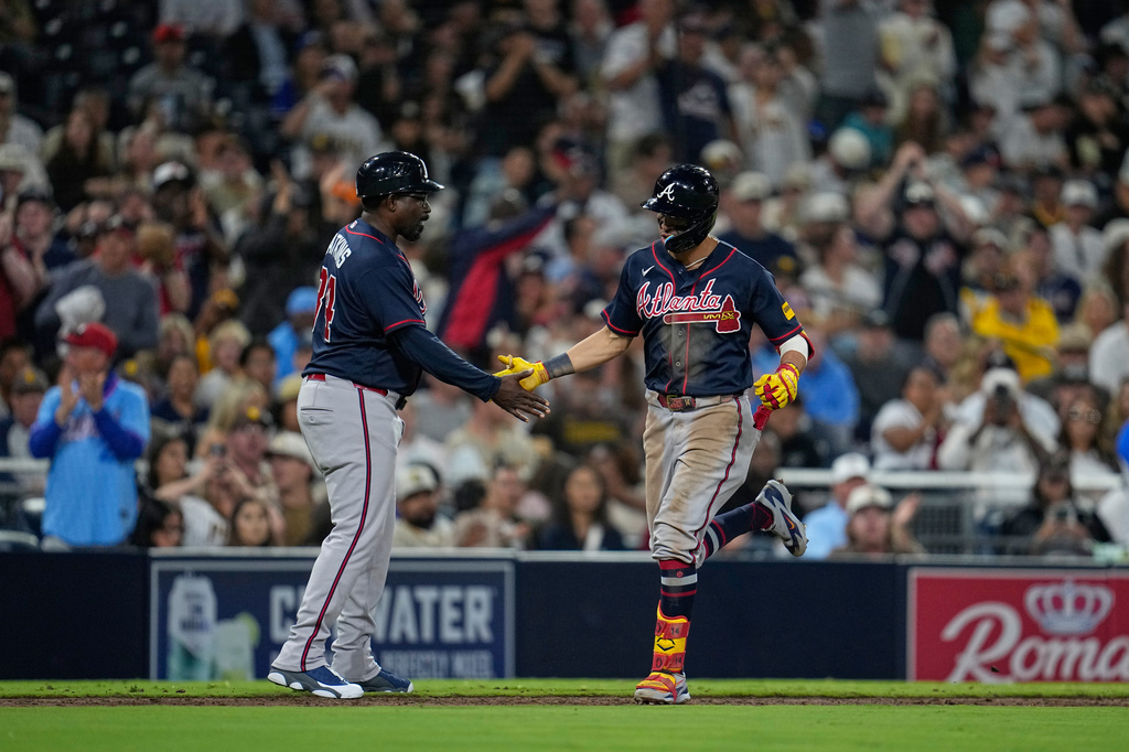 Atlanta Braves' Mauricio Dubón, right, celebrates with third base coach Tommy Watkins after hitting a home run during the fifth inning of a baseball game against the San Diego Padres Tuesday, June 23, 2026, in San Diego. (AP Photo/Gregory Bull)