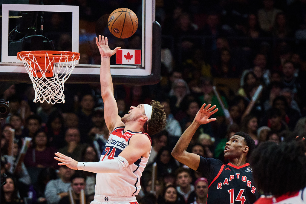 Washington Wizards' Corey Kispert (24) drives to the net past Toronto Raptors' Ja'Kobe Walter (14) during first half NBA Cup basketball action in Toronto, Friday, Nov. 21, 2025. (Sammy Kogan/The Canadian Press via AP)