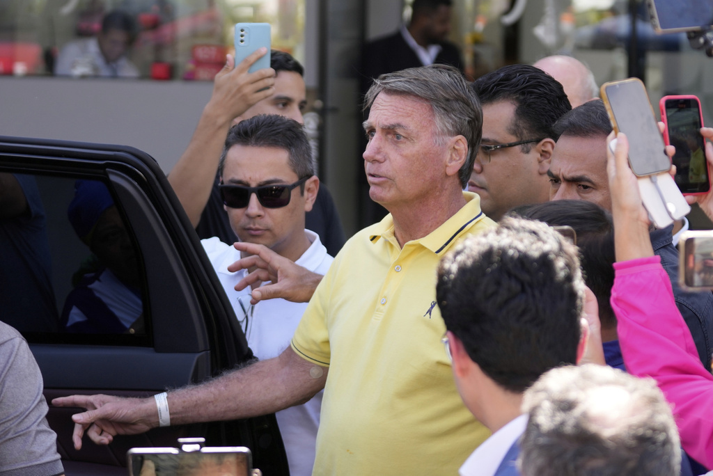 Brazil’s former President Jair Bolsonaro, center, temporarily allowed out of house arrest for medical exams, departs a hospital in Brasília, Brazil, Saturday, Aug. 16, 2025. (AP Photo/Eraldo Peres)